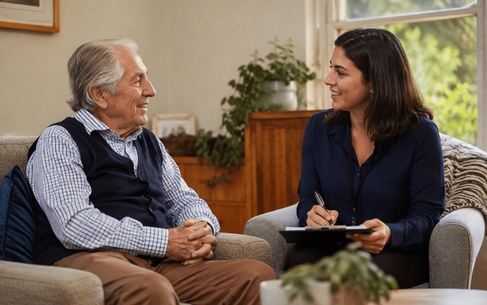 Assessor and older person seated together in a lounge room, relaxed, at the same eye level